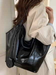 Glossy black leather tote bag with round coin purse accessory for daily commuting style