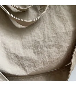 Close-up of beige tote bag showing soft nylon fabric texture and stitching details