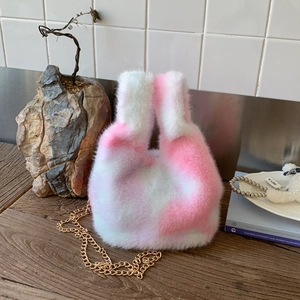 Detail of pink and white plush bucket bag showing fluffy texture and gold chain strap