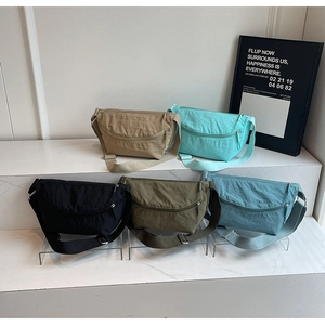 Detailed view of minimalist nylon crossbody bags in five colors on marble steps