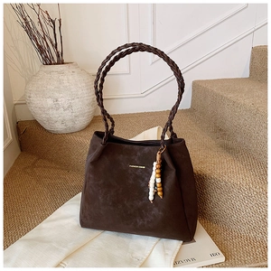 Detail of vintage coffee brown tote bag with woven handles and beaded tassel charm