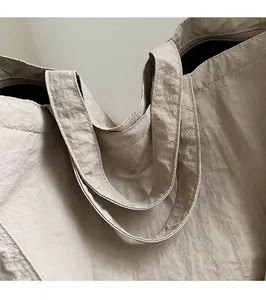 Detailed close-up of reinforced stitching and secure zipper on the khaki tote bag