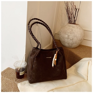 Detailed view of the dark brown matte tote bag with braided straps and wood bead charms