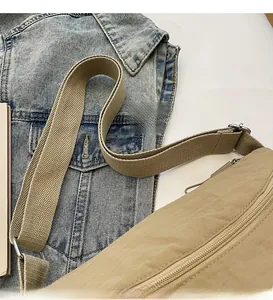 Detail of adjustable khaki canvas shoulder strap with metal buckle and smooth zipper