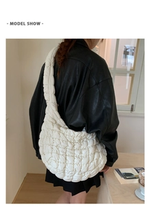 Nahaufnahme der gesteppten Bubble-Schultertasche mit breitem Gurt an Model in Lederjacke