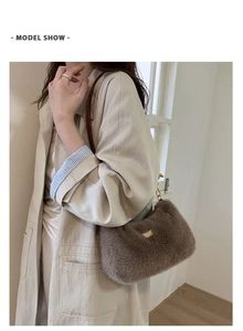 Sac bandoulière en peluche marron avec chaîne en métal porté par un mannequin en trench
