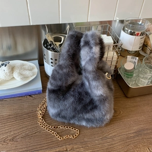 Detail of plush bucket bag with marble faux fur texture and delicate gold metal chain