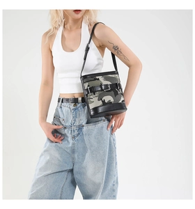 Detail of camouflage bucket bag with black leather strap and buckle on model