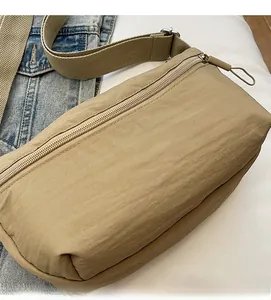 Close-up of khaki nylon fabric texture with adjustable strap and metal buckle on crossbody bag