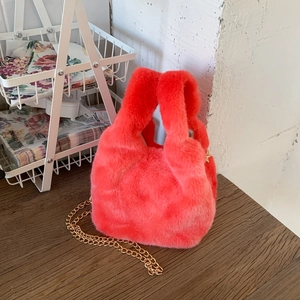Detail of coral plush tote bag with long faux fur texture and a gold chain strap
