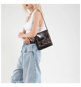 Détail du sac à bandoulière léopard avec garnitures en cuir noir et boucle métallique