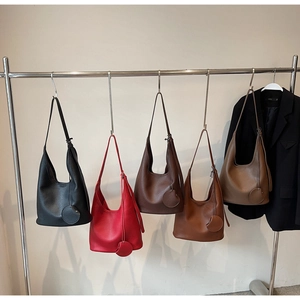 Litchi pattern leather tote bags in five colors displayed on a sleek metal rack