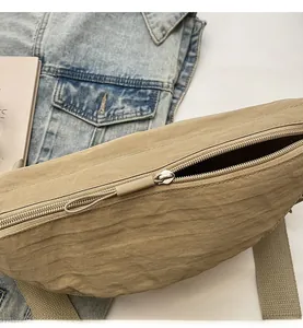 Detail of smooth zipper closure with long puller on minimalist nylon crossbody bag