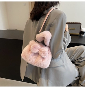 Vue détaillée du sac à bandoulière rose en fausse fourrure avec nœud en peluche et cœur