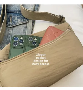 Close-up of khaki nylon crossbody bag interior with zipper storage for phone and wallet