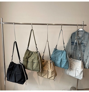 Detail of multi-color nylon shoulder bags with drawstring closure and cargo pockets