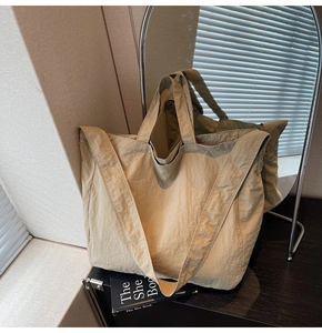 Détail macro du grand sac cabas en nylon beige avec poignées et bandoulière amovible