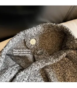 Detail of magnetic snap closure on textured wool tote bag with thick plush fabric lining
