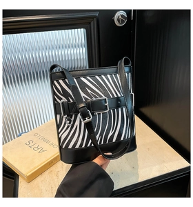 Détail du sac seau à motif zébré avec finitions en cuir noir et boucle en métal chromé