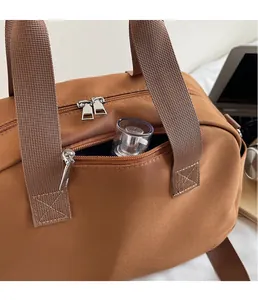Close-up of brown canvas tote showing zipper pockets and spacious storage space