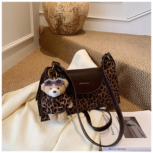 Détail du sac à bandoulière léopard en similicuir avec charm ours en peluche et anneaux