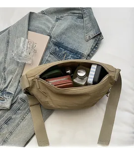 Spacious interior of khaki crescent nylon bag showing storage for wallet and notebook