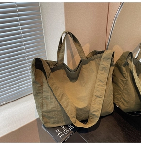 Détail du sac cabas en nylon vert armée avec poignées renforcées et large bandoulière