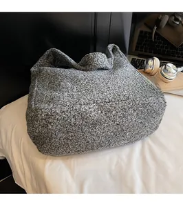Close-up of gray tweed tote bag showing thick wool blend texture and wide shoulder strap