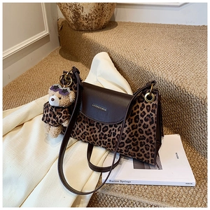 Détail du sac léopard avec rabat en cuir marron et charm de poupée ours vintage