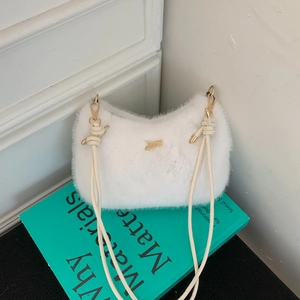 Détail du sac en peluche blanche avec ferrures dorées et bandoulière en cuir nouée
