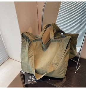 Vue détaillée du grand cabas en nylon vert olive avec texture plissée en mise en scène