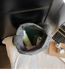 Top view of spacious interior of grey fuzzy tote bag with tablet, water bottle and phones
