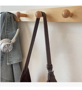 Detail of reinforced leather handle on a dark brown bucket bag with casual lifestyle props