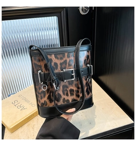 Vue détaillée du sac seau léopard avec finitions en cuir noir et boucle en métal argenté