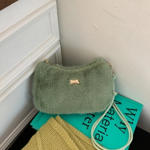 Détail du sac en fausse fourrure verte avec logo doré et fine bandoulière en cuir