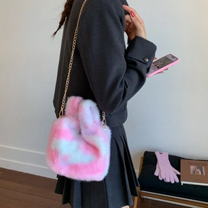 Detail shot of a plush shoulder bag with pink and white gradient fur and gold chain