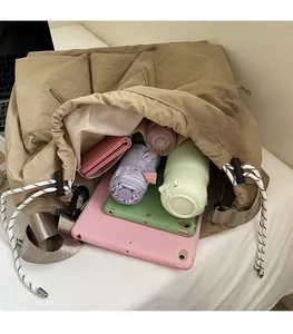 Spacious interior of khaki drawstring tote bag showing high capacity for tablets and bottles