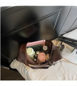 Top view of spacious brown pebbled leather tote bag holding a tablet and daily essentials