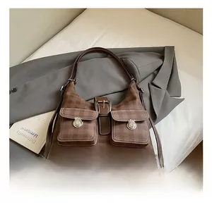 Detailed view of checkered brown tote bag with twin front pockets and metallic buckles