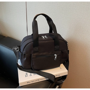 Detail view of durable black nylon tote bag with double handles and adjustable shoulder strap