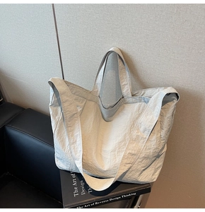 Gros plan du grand sac cabas gris clair en tissu froissé avec une large bandoulière