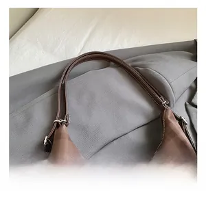Close-up of brown checkered tote bag with contrast stitching and metal buckle details