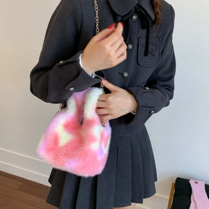 Close-up of pink and purple fuzzy plush bucket bag with golden chain and soft faux fur
