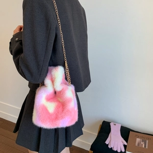 Detail view of pink and white plush faux fur bucket bag with golden chain strap