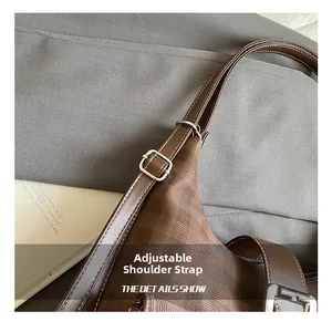 Detail of adjustable shoulder strap with silver buckle on dark brown checkered tote bag