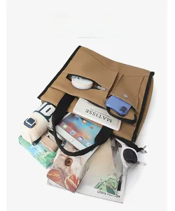 Detailed top view of a large brown canvas tote bag with organized internal storage compartments