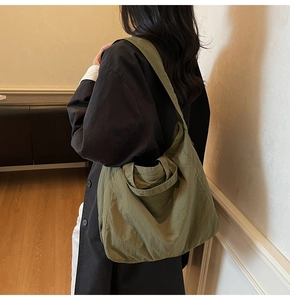 Détail d'un grand sac cabas vert armée montrant la texture nylon souple et la forme hobo