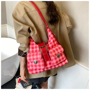 Close-up of vintage pink plaid crossbody bag featuring dual front utility pockets