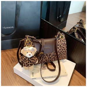 Détail du sac léopard vintage avec un charmant ours en peluche et un logo métallique
