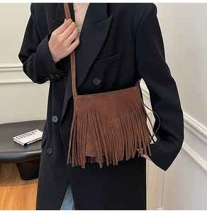 Detail der dunkelbraunen Wildleder-Umhängetasche mit dichten Fransen im Boho-Stil